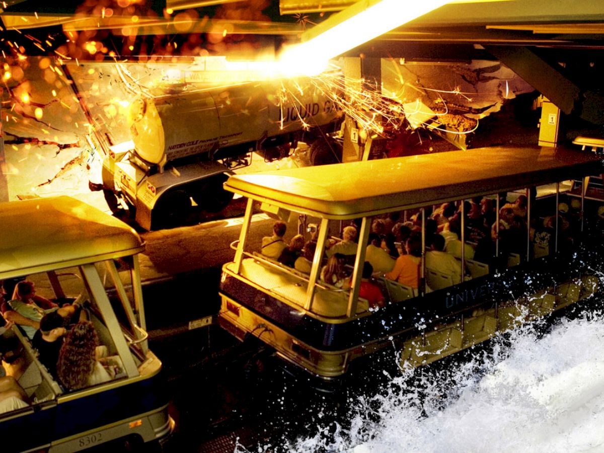 The image shows a thrilling scene with trams carrying passengers through a simulated disaster with an explosion and cascading water.